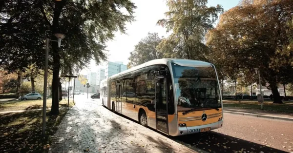 Bus van Qbuzz rijdend door een Nederlandse stad, symbool voor openbaar vervoer en verbinding.